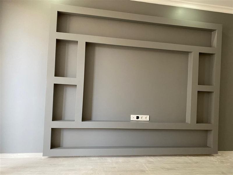 Tamamlanmış, gri tonda boyanmış bir TV ünitesi duvarı