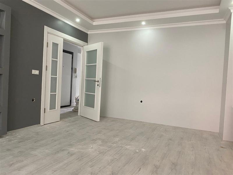 Koyu aksan duvarı ve beyaz kapısıyla tamamlanmış bir daire odası