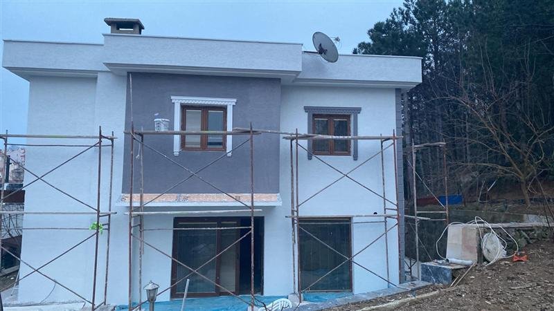 Dekoratif pencere kaplamaları ve iki tonlu doku ile tamamlanmış bir bina cephesi